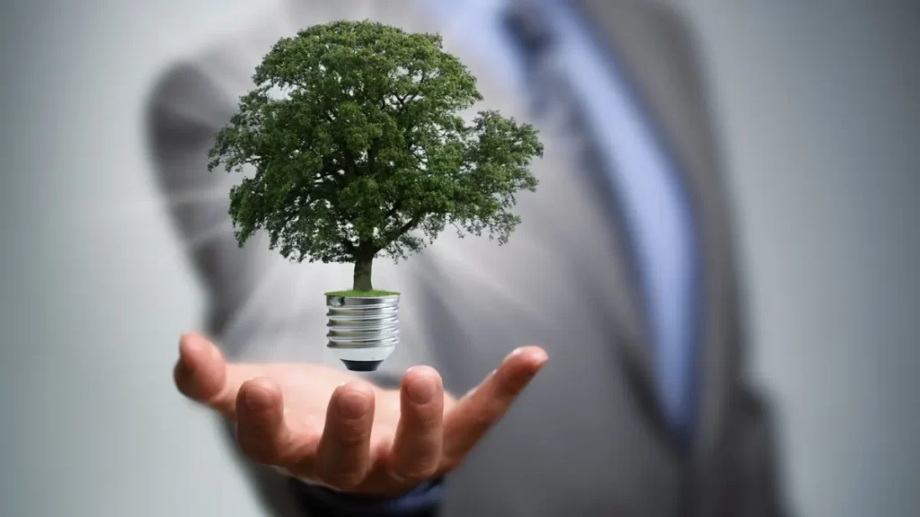 Business man holding a tree lightbulb